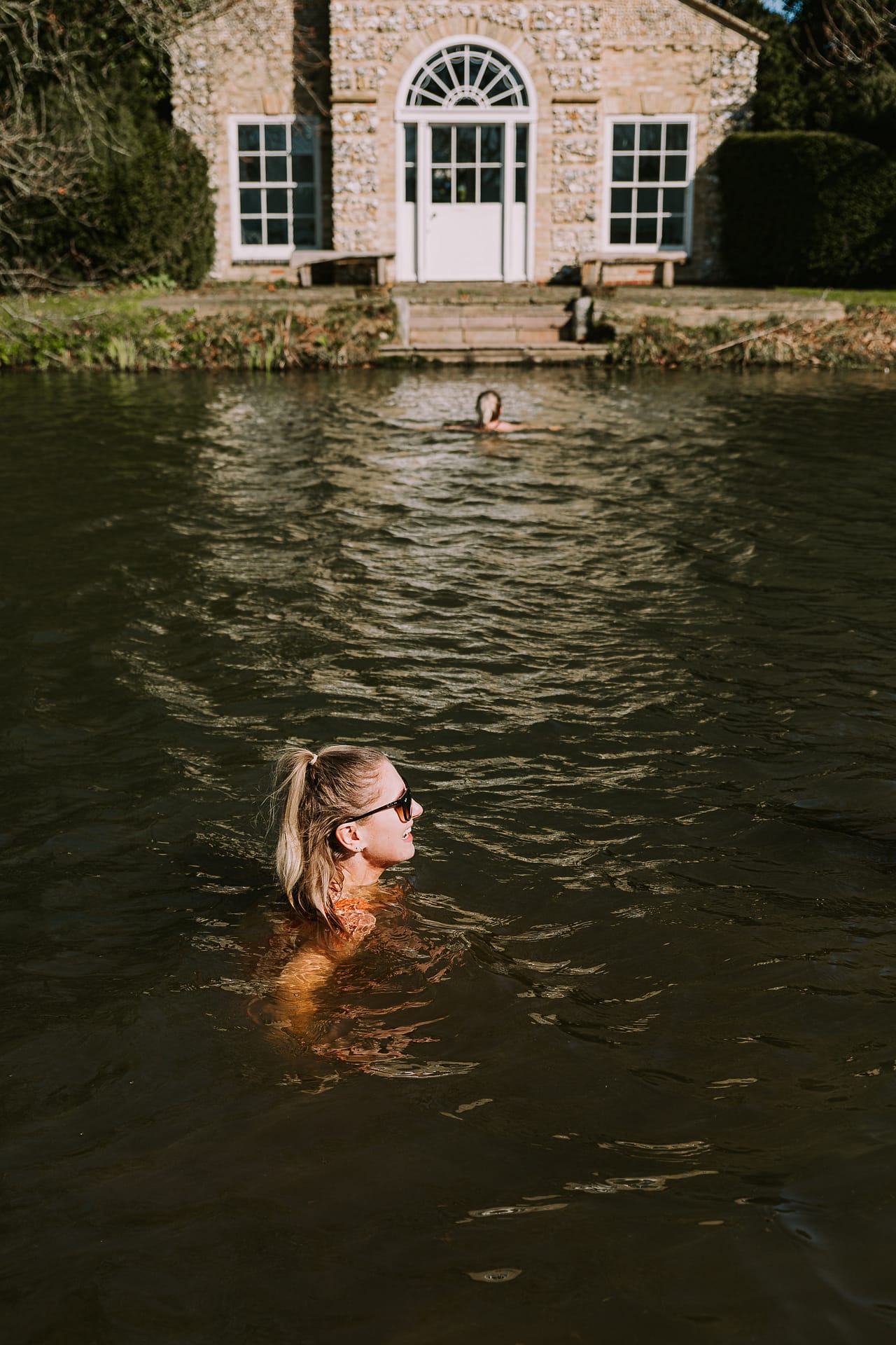 women_wild_swimming_in_lake_in_front_of_cottage