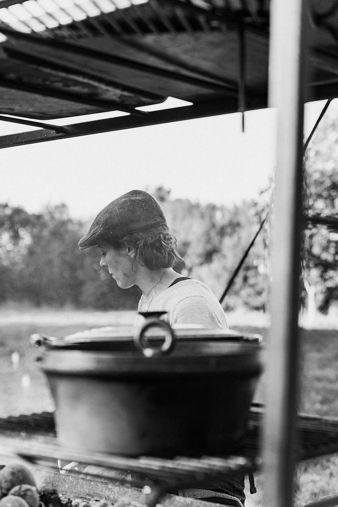 woman behind steaming pot in black and white