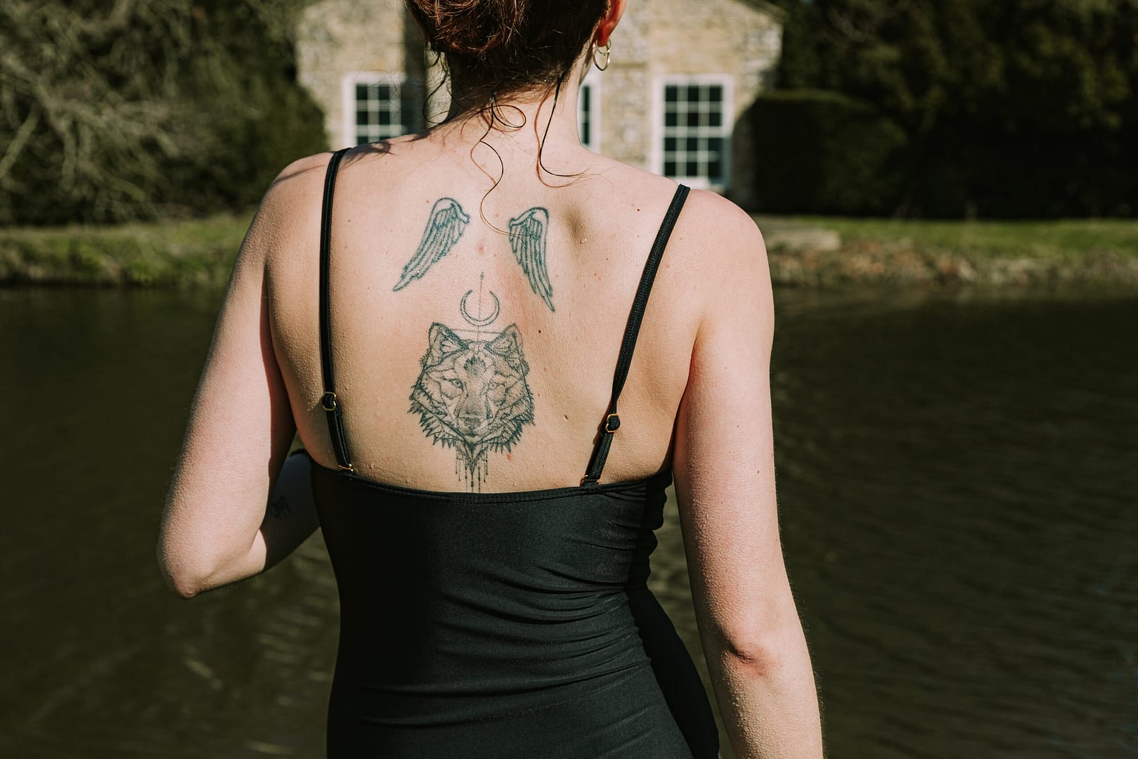 Tattooed_girl_with_wolf_in_front_of_lake