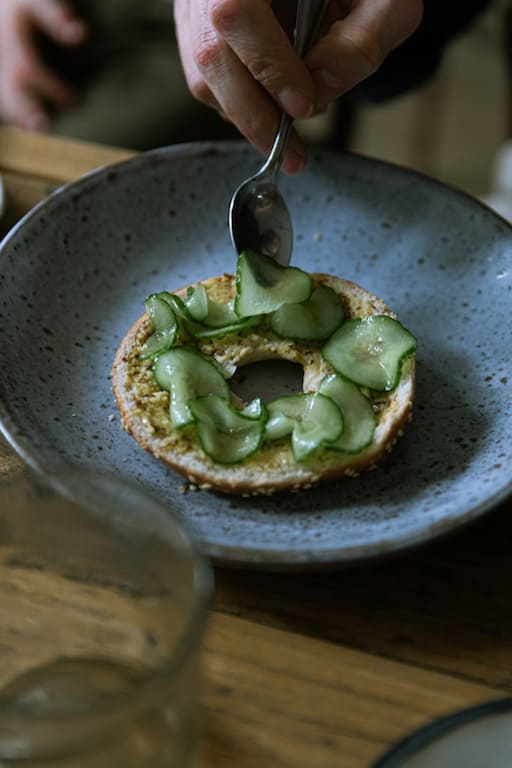 Pickeld cucumber added to a bagel