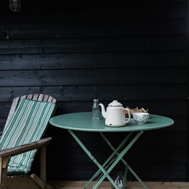 Zinc table on terrace with enamel teapot and tea cup