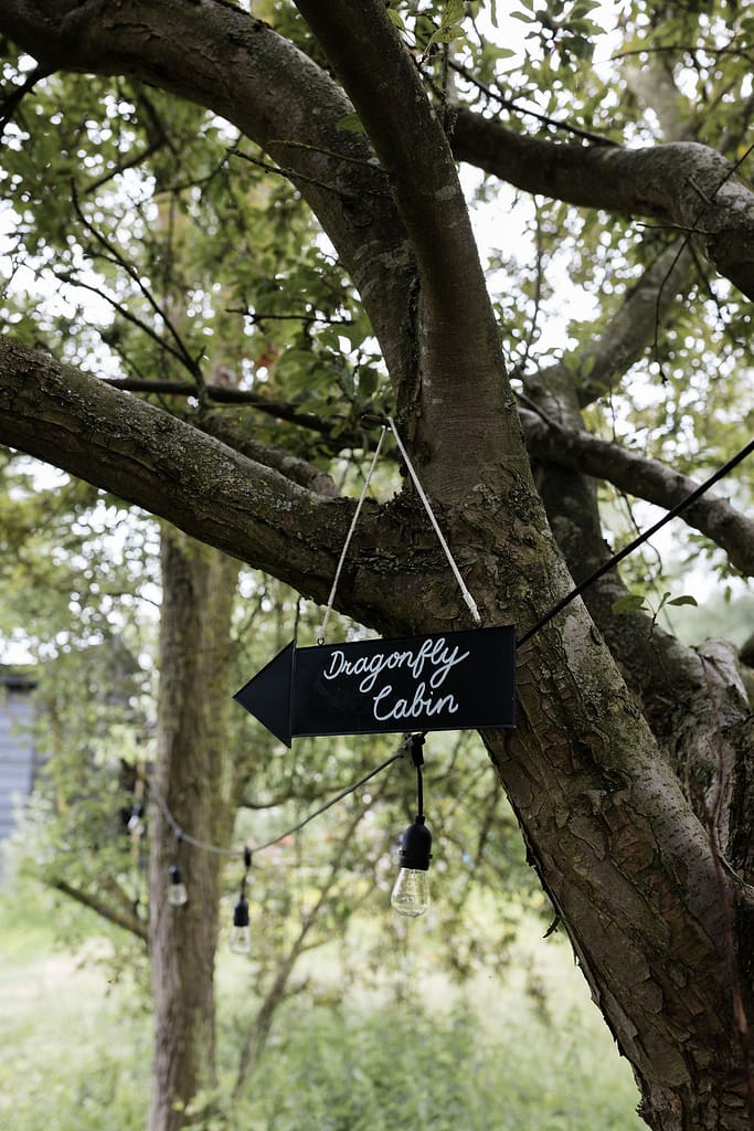 black slate sign hanging off a tree for Dragonfly Cabin