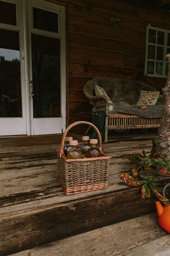 Basket full of bottles and rustic staircase in cabin