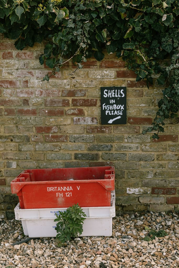 a white and red tray under a sign that reads dispose of oysters here