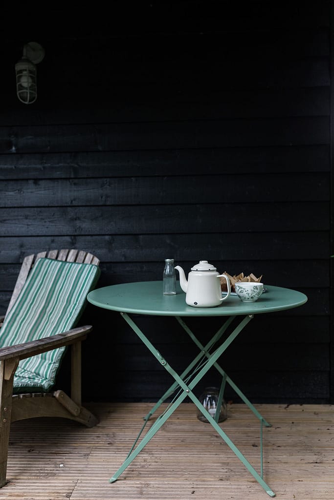 Zinc table on terrace with enamel teapot and tea cup